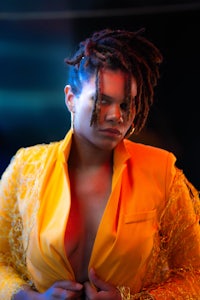 a woman with dreadlocks in a yellow jacket