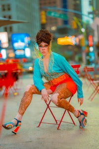 a woman sitting on a chair in a city