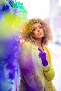 a woman wearing a yellow jacket and purple gloves